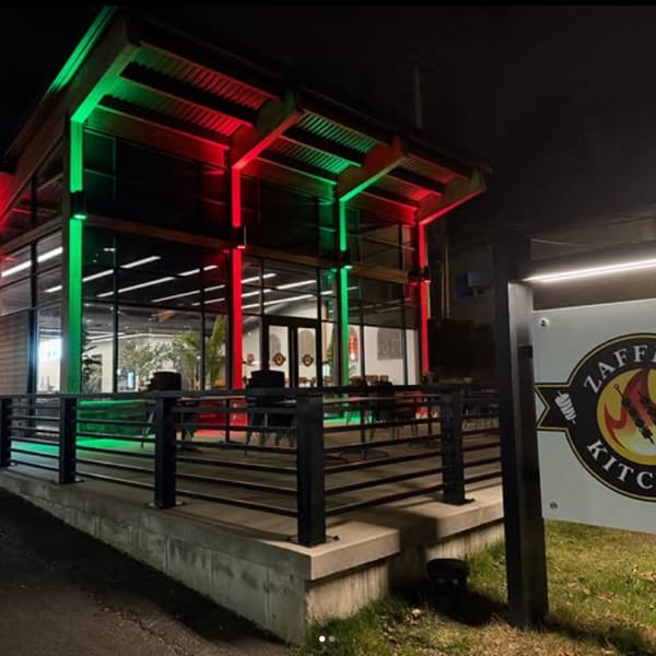 Zaffron Kitchen restaurant exterior at night, illuminated with festive red and green lights.