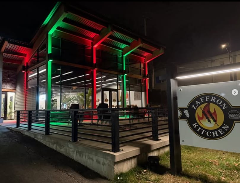 Zaffron Kitchen restaurant exterior at night, illuminated with festive red and green lights.