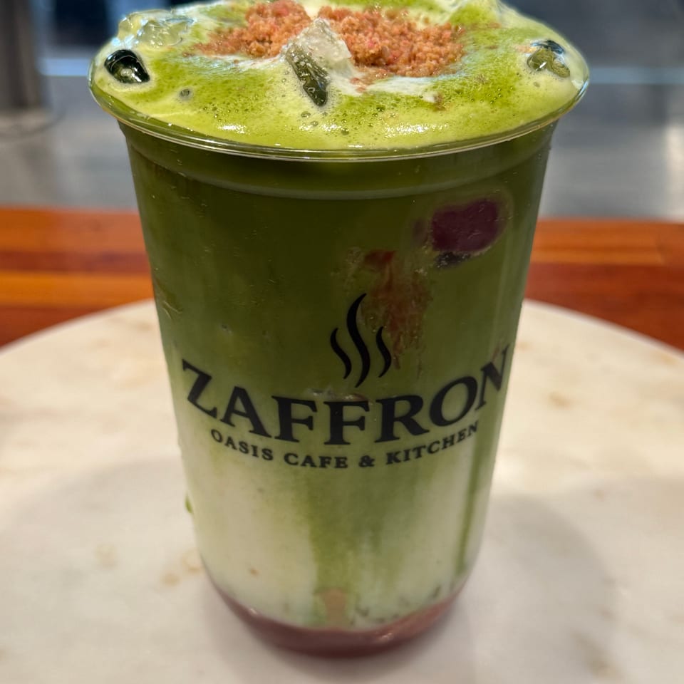 Zaffron Oasis Cafe & Kitchen's layered green and white drink with red sprinkles and ice.